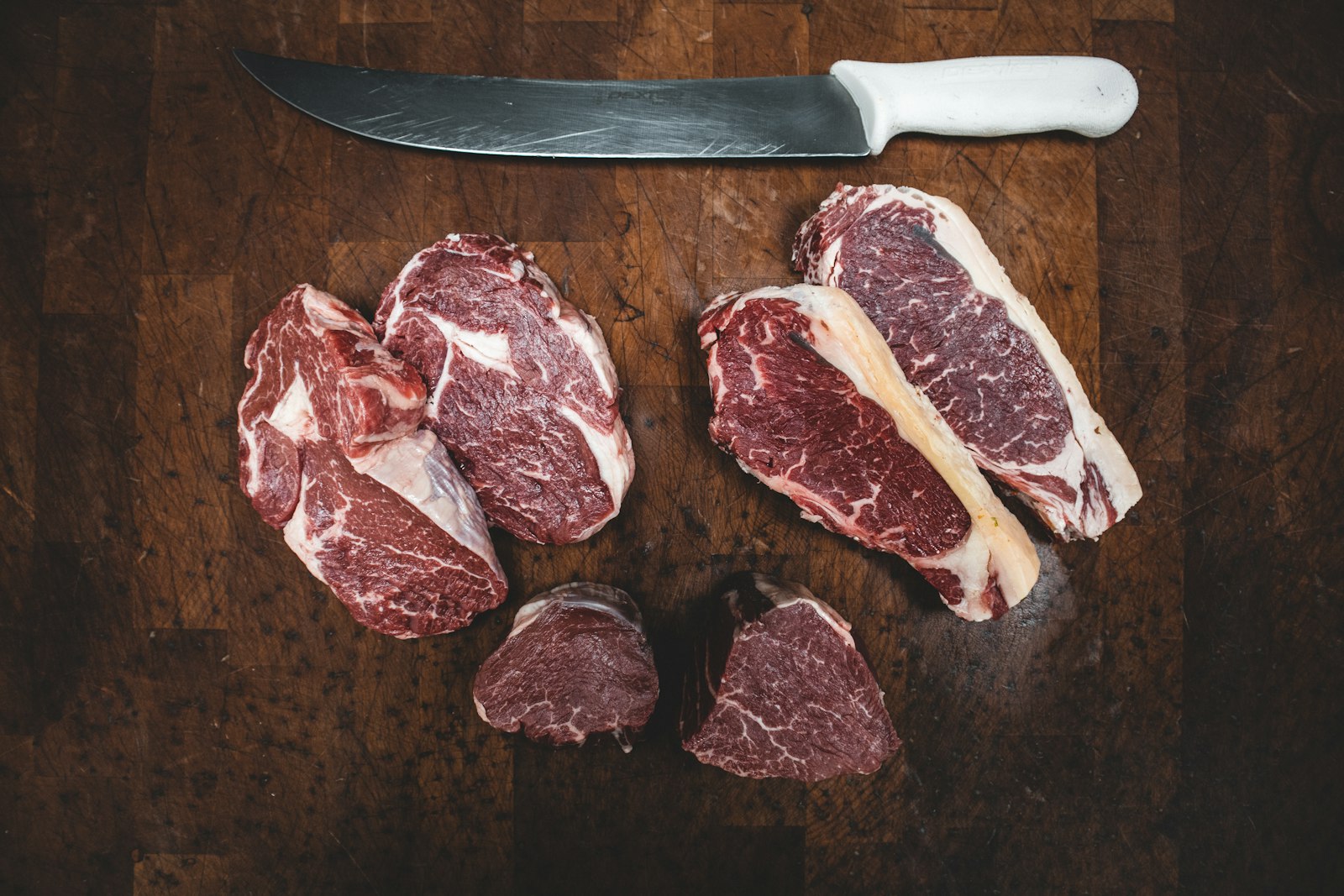 Steaks and knife on a heritage butcher block